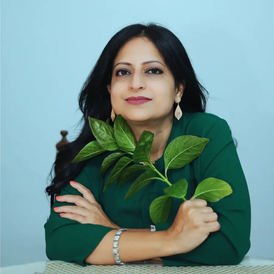 Dr. Shruti Upadhyay smiling, holding a fresh green leaf